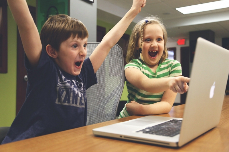 Children celebrating winning on computer